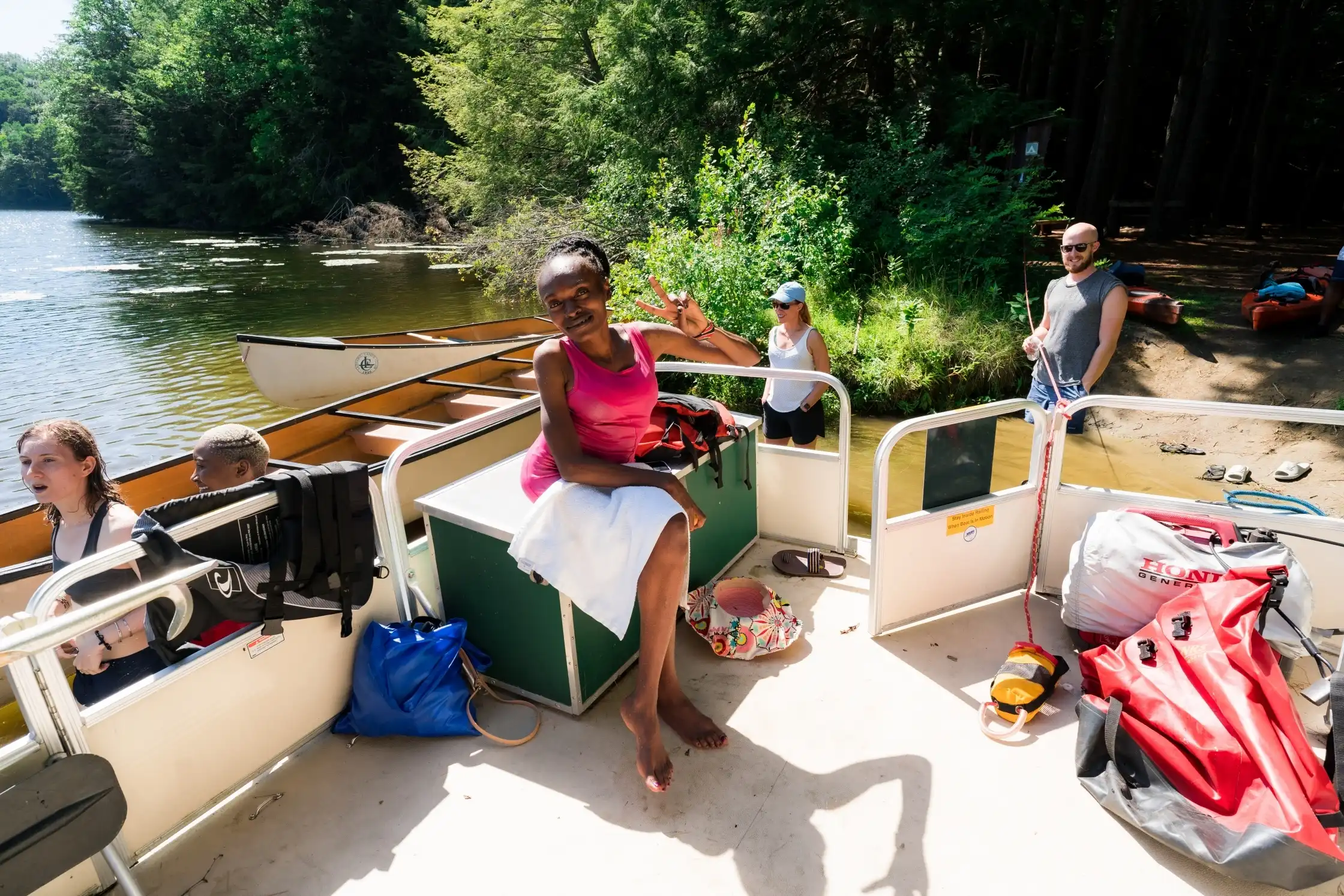Women on a pontoon boat making a peace sign